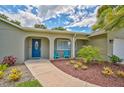 Inviting front entrance featuring a blue front door, outdoor seating, and lovely landscaping at 8007 17Th Nw Ave, Bradenton, FL 34209