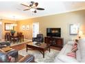 Comfortable living room with a ceiling fan, TV, and adjacent dining area at 8078 Stirling Falls Cir, Sarasota, FL 34243