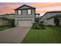 Charming two-story home featuring a manicured lawn, attached garage, and attractive landscaping at 8815 Windlass Cv, Parrish, FL 34219