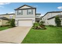 Charming two-story home with light grey siding, well-manicured lawn, and an attached two-car garage at 8815 Windlass Cv, Parrish, FL 34219