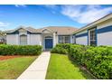A beautiful home with a well-maintained lawn, blue door, and trimmed bushes at 9402 71St E Ave, Palmetto, FL 34221