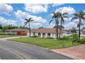 Charming single-story home boasting a beige tile roof, well-kept lawn, and mature palm trees at 107 Van Dyck Dr, Nokomis, FL 34275