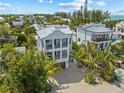 Expansive aerial view of this luxury home, beautifully landscaped with tropical palms and manicured lawn at 109 Palmetto Ave, Anna Maria, FL 34216