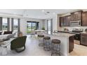 Open-concept kitchen featuring a granite island with barstool seating, and stainless steel appliances at 12047 Kingsley Trl, Parrish, FL 34219