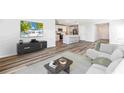 Open-concept living room featuring modern decor, wood floors, and seamless kitchen access at 12064 Lansing Gln, Parrish, FL 34219