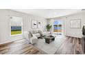 Inviting living room with comfortable seating, wood floors, and scenic lake view at 12064 Lansing Gln, Parrish, FL 34219