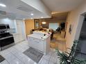 Open concept kitchen with tile flooring, white cabinetry, and stainless steel appliances at 1211 Capri Isles Blvd # 116, Venice, FL 34292