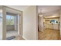 Entryway view with wood-look flooring transitioning into the kitchen with white appliances and ample counter space at 137 Woodland Pl, Osprey, FL 34229