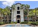 Beautiful condo complex, showcasing an arched entrance and multiple balconies surrounded by palm trees at 16804 Vardon Ter # 307, Bradenton, FL 34211