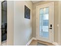 Elegant foyer featuring a decorative accent wall, a stylish front door, and sleek flooring at 17898 Cherished Loop, Bradenton, FL 34211