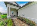 Inviting front porch with cozy seating area and beautifully landscaped entryway at 17898 Cherished Loop, Bradenton, FL 34211