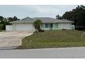 Exterior of home showcasing lush lawn, side privacy fence, and two-car garage in a sunny neighborhood at 20170 Tralee Dr, Port Charlotte, FL 33952