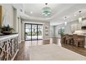 Bright living area featuring wood floors, tray ceiling, and sliding glass doors to outdoor patio at 208 Ariano Ave, Nokomis, FL 34275