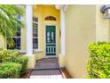 Detailed front entrance with a green door framed by white pillars and manicured greenery at 2085 Mattamy Ct, Venice, FL 34292