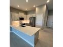 Modern kitchen with white cabinets, stainless steel appliances, and a spacious countertop at 24827 Buckingham Way, Port Charlotte, FL 33980