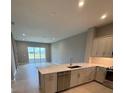 Bright kitchen featuring an island, stainless steel appliances, and a view of the backyard at 24827 Buckingham Way, Port Charlotte, FL 33980