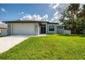 Charming single-story home with a manicured lawn, a two-car garage, and fresh modern landscaping at 2546 Malibu Ln, North Port, FL 34286
