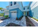 The property features light blue siding, a brick paver driveway, and manicured landscaping at 317 Via Tuscany Ave, Sarasota, FL 34243