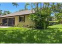 Exterior view of home featuring well-maintained lawn, tropical foliage, and screened lanai at 3311 39Th W Pl, Bradenton, FL 34205