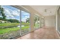 Enclosed patio with tile flooring, a ceiling fan, and large windows overlooking a tranquil pond at 3317 Highlands Bridge Rd # 61, Sarasota, FL 34235