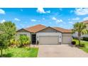 Charming single-story home with a three-car garage, lush landscaping, and a brick-paved driveway at 3504 Big Sky Way, Bradenton, FL 34211