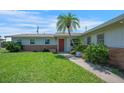 Landscaped front yard with a vibrant lawn leading to the inviting entrance of the home at 3621 S Lockwood Ridge Rd, Sarasota, FL 34239