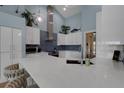 Bright, open-concept kitchen with white cabinets, quartz countertops, and a stainless steel range hood at 4120 51St W Dr, Bradenton, FL 34210