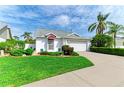 Inviting home with lush green lawn, mature palms, and a convenient two-car garage at 4227 Placid Dr, Sarasota, FL 34243