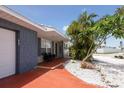 Welcoming front porch with stone accents, a cozy bench, and lush tropical landscaping at 4303 83Rd W St, Bradenton, FL 34209