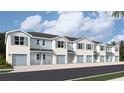 Beautiful townhome exterior featuring light and blue stucco, blue shutters and garage door at 4613 Pleasant Ave, Palm Harbor, FL 34683