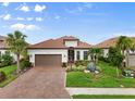 Beautiful single-story home with a red tile roof, brick driveway, lush landscaping, and a two-car garage at 4720 Arpino Ct, Bradenton, FL 34211