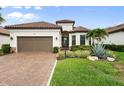 Charming single-Gathering home with a brown tile roof, manicured lawn, and a two-car garage at 4720 Arpino Ct, Bradenton, FL 34211