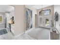 Bright entryway featuring neutral walls, a large abstract painting, tile floors, and a double-door entry with transom window at 5142 51St W Ln, Bradenton, FL 34210
