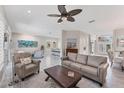 Spacious living area with tile floors, a ceiling fan, comfortable seating, and an open layout with views of the entryway at 5142 51St W Ln, Bradenton, FL 34210