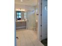 Well-lit bathroom featuring a glass enclosed shower, modern vanity, and white tiled floor at 5219 Barnett Cir, Bradenton, FL 34211