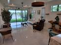 Bright living room with tile floors, large glass doors to backyard, modern furniture and stylish decor at 5219 Barnett Cir, Bradenton, FL 34211