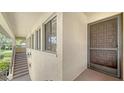 Entrance to the condo with a screened in door and a view of the tropical community at 5255 Lake Village Dr # 40, Sarasota, FL 34235