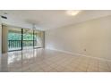 Bright and airy living room featuring tiled floors and a sliding glass door to a private balcony at 5255 Lake Village Dr # 40, Sarasota, FL 34235