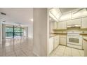 Open living space flows to the kitchen with tile floors and a balcony overlooking the tropical community at 5255 Lake Village Dr # 40, Sarasota, FL 34235