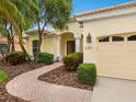 Attractive home with well-kept landscaping, a brick pathway, and an attached two-car garage at 6811 Honeysuckle Trl, Lakewood Ranch, FL 34202