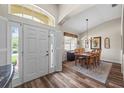 Entryway view featuring a modern chandelier over a wood dining table and wood-look flooring at 743 Stonecrest Dr, Sarasota, FL 34232