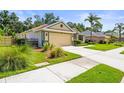 View of the home showcasing a well-manicured lawn, a two-car garage, and a landscaped front yard at 743 Stonecrest Dr, Sarasota, FL 34232