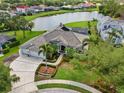 Stunning aerial view of a luxurious home with a tiled roof, manicured landscaping, and a serene lake backdrop at 7513 Coventry Ct, Lakewood Ranch, FL 34202