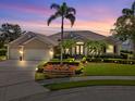 Charming one-story home featuring tropical landscaping, manicured lawn, and tasteful exterior lighting at 7513 Coventry Ct, Lakewood Ranch, FL 34202