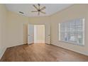 Spacious bedroom featuring wood-look floors, neutral walls, and a large window with shutter blinds at 8382 Creekview Ln, Englewood, FL 34224