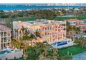 Beautiful multi-story home featuring expansive balconies, a pool, manicured lawns, and tropical landscaping at 845 Longboat Club Rd, Longboat Key, FL 34228