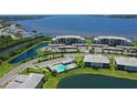 Aerial view showcasing a condo community with a swimming pool, waterfront access, and lush surroundings at 850 Tidewater Shores Loop # 108, Bradenton, FL 34208