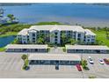 Condo exterior featuring covered parking, lush landscaping, and tranquil waterfront views at 850 Tidewater Shores Loop # 108, Bradenton, FL 34208