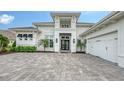 Beautiful white home featuring a modern black front door and paved driveway at 8537 Pavia Way, Bradenton, FL 34202