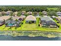 A serene backyard view showcasing the home, lawn, nearby lake, and neighboring residences at 8772 Stone Harbour Loop, Bradenton, FL 34212